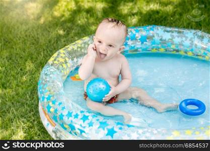 Adorable baby boy enjoying swimming in pool