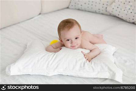 Adorable baby boy relaxing on big pillow after bathing