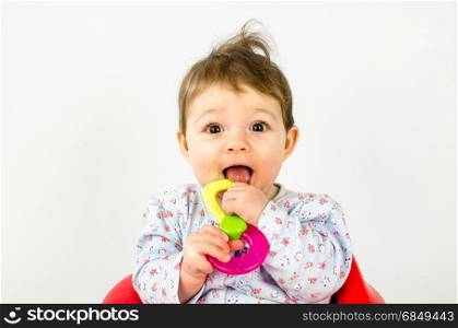 adorable baby girl teething and chewing teethers