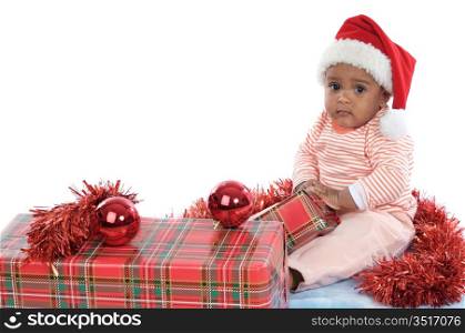 Adorable baby girl with christmas presents and santa hat