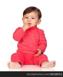 Adorable baby girl with her hand in mouth sitting isolated on white background
