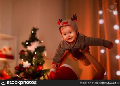 Adorable baby having fun near Christmas tree &#xA;