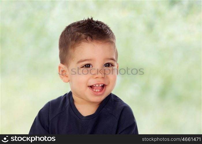 Adorable baby nine months looking at camera with green background