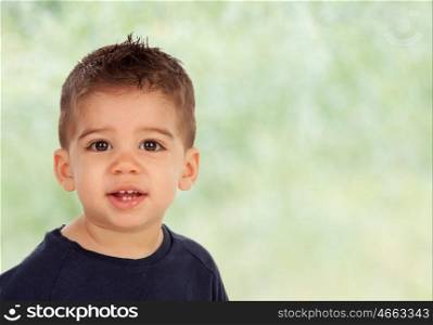 Adorable baby nine months looking at camera with green background
