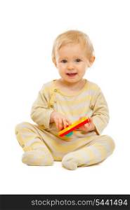 Adorable baby sitting on floor and playing with rattle isolated on white