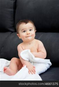 Adorable baby with a towel at home