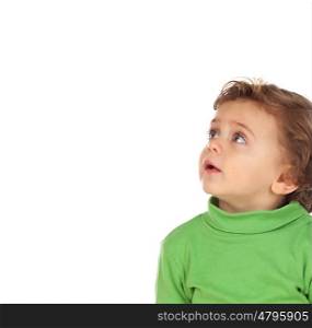 Adorable baby with green shirt looking up isolated on a white background