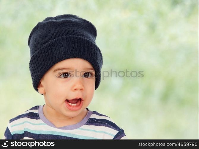 Adorable baby with wool cap and green background