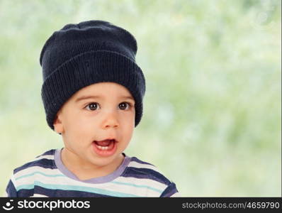 Adorable baby with wool cap and green background