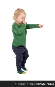 Adorable blond baby indicating something isolated on a white background