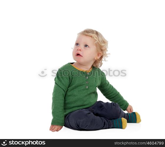 Adorable blond baby sitting on the floor isolated on a white background