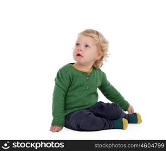 Adorable blond baby sitting on the floor isolated on a white background