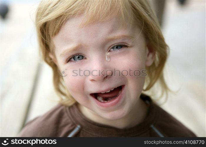 Adorable blond little girl crying closeup portrait