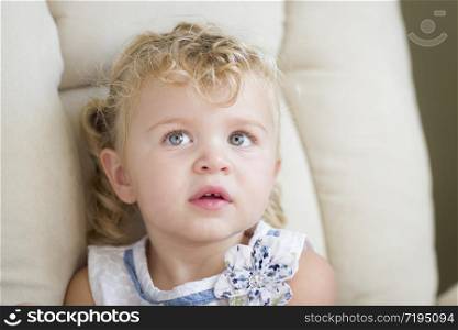 Adorable Blonde Haired and Blue Eyed Little Girl Sitting in Chair.