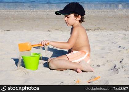 adorable boy playing in the beach in summer