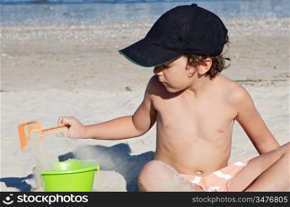 adorable boy playing in the beach in summer