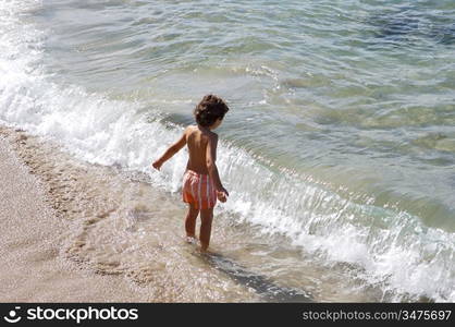 adorable boy playing in the beach over a white background