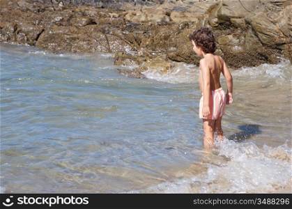 adorable boy playing in the beach over a white background