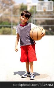 Adorable boy with basketball, outdoors
