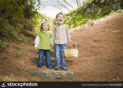 Adorable Brother and Sister Children Holding Hands Walking Down Wood Steps with Basket Outside.