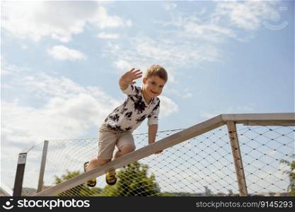 Adorable caucasian boy climbing on metal handrail outdoor. Cute child having fun in the city. Active leisure. Beautiful view, blue sky, amazing sunny weather. Go forward, climb to the top. Adorable caucasian boy climbing on metal handrail outdoor. Cute child having fun in the city. Active leisure. Beautiful view, blue sky, amazing sunny weather. Go forward, climb to the top.