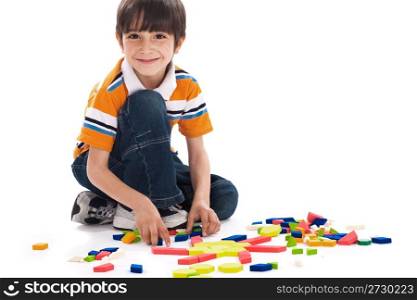 Adorable caucasian boy joining the blocks while playing on white background