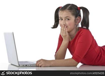 Adorable caucasian little girl lying with laptop