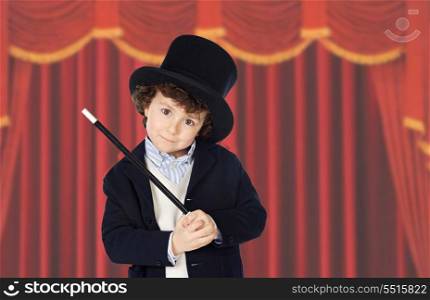 Adorable child dress of illusionist with hat and red curtains of background