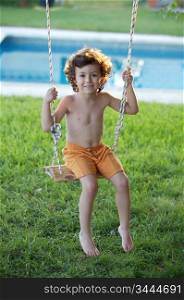 adorable child playing in a swing in the pool