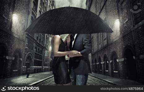 Adorable couple under the black umbrella