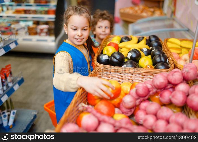 Adorable girl in uniform playing saleswoman, playroom. Kids plays sellers in imaginary supermarket, salesman profession learning
