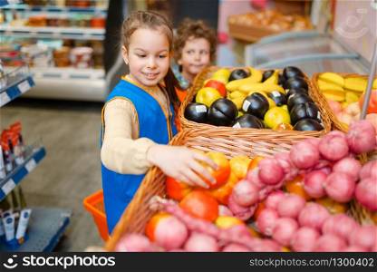 Adorable girl in uniform playing saleswoman, playroom. Kids plays sellers in imaginary supermarket, salesman profession learning