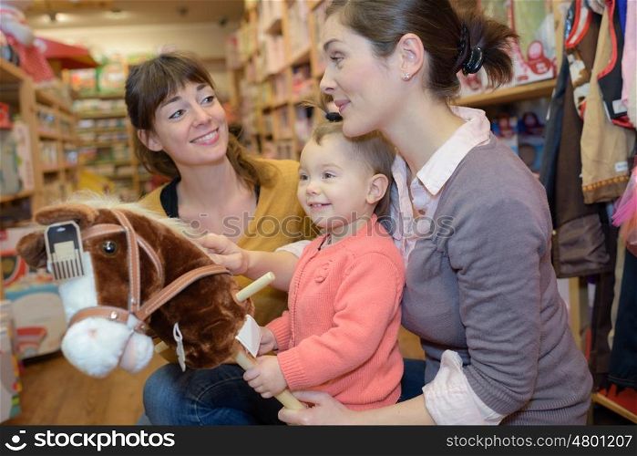 adorable girl look to toys at toy store with mother