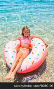 Adorable girl on inflatable air mattress in the clear sea. Adorable girl on inflatable air mattress in the sea