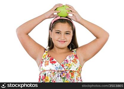 Adorable girl with flowered dress with a apple on her head on a white background