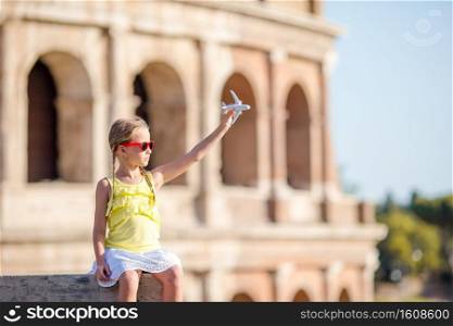 Adorable girl with small toy model airplane background Colosseum in Rome, Italy. Young girl in front of Colosseum in rome, italy