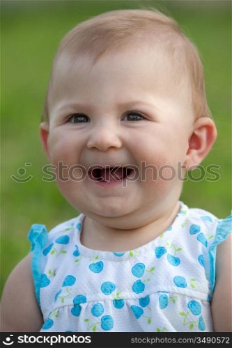 Adorable happy baby girl on the green grass
