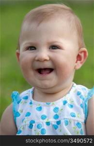 Adorable happy baby girl on the green grass