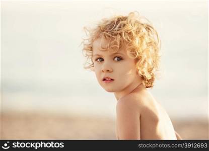 Adorable happy little girl on beach vacation, close up portrait