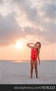 Adorable happy little girl on white beach at beautiful sunset. Adorable happy little girl on white beach at sunset.