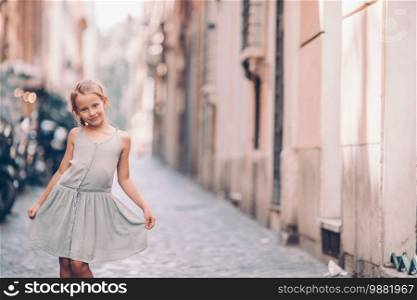 Adorable happy little girl outdoors in european city. Portrait of caucasian kid enjoy summer vacation in Rome. Adorable fashion little girl outdoors in European city Rome
