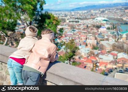 Adorable kids with beautiful view of old city Tbilisi. Beautiful view of old city. Summer Cityscape.. Tbilisi city panorama. Old city, new Summer Rike park, river Kura, the European Square and the Bridge of Peace