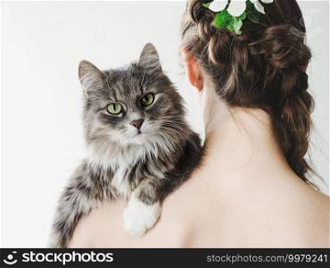 Adorable kitten lying on the shoulder of a beautiful woman. Side view, close-up. Studio photo. Pet care concept. Adorable kitten lying on the shoulder of a woman