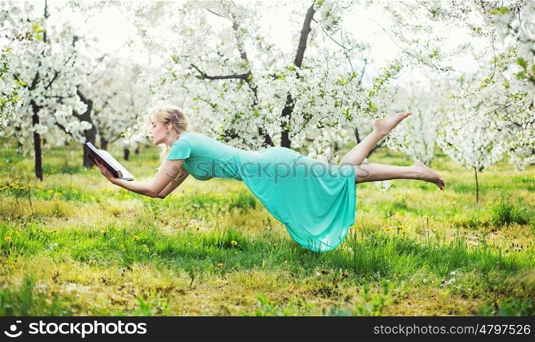 Adorable lady levitating during book reading
