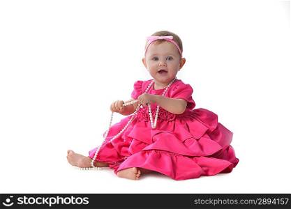 Adorable little baby girl in pink dress sitting on floor