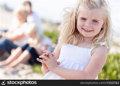 Adorable Little Blonde Girl Having Fun At the Beach with Her Family.