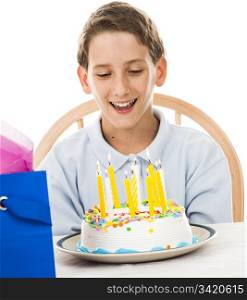 Adorable little boy gets ready to blow out the candles on his birthday cake. White background.