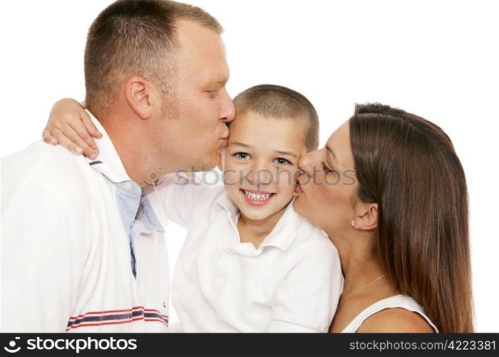 Adorable little boy getting kisses from his mother and father. Isolated on white.