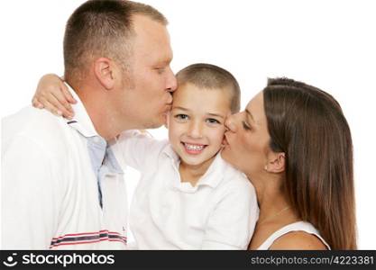 Adorable little boy getting kisses from his mother and father. Isolated on white.