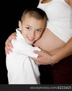 Adorable little boy listening to his mother&rsquo;s pregnant belly.
